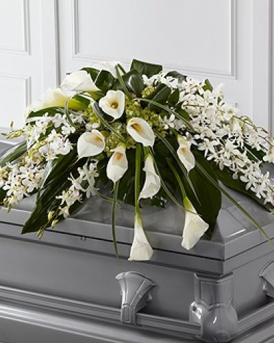 The FTD® Angel Wings™ Casket Spray is an exceptionally gorgeous way to bring peace and beauty to their final farewell service. White Dendrobium orchids, white calla lilies, green hydrangea and a variety of lush greens are artfully arranged to perfectly adorn the top of their casket, offering the colors and ambience of grace and serenity.