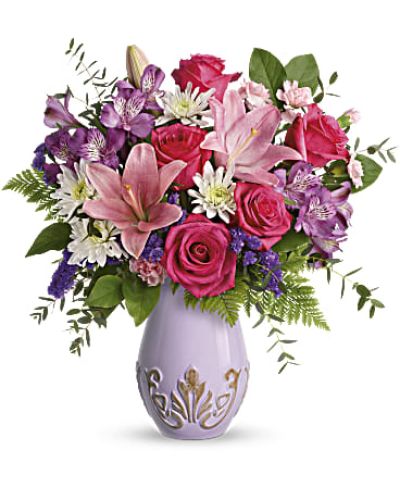 Lavish her in love this Mother's Day with pink roses and lilies, presented to perfection in a fabulous French-inspired purple vase with elegant embossed details.
This feminine bouquet includes hot pink roses, pink asiatic lilies, purple alstroemeria, miniature pink carnations, white cushion spray chrysanthemums, purple sinuata statice, leatherleaf fern, parvifolia eucalyptus, and lemon leaf. ? Delivered in Teleflora's Lavishly Lavender Vase.
Orientation: All-Around