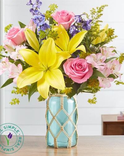 Celebrate spring with garden-meets-coastal style. Our loosely gathered bouquet is designed exclusively in partnership with Real Simple, and features a bright mix of blooms. Arranged in our sea green jar inspired by repurposed glass, with an eco-friendly, handmade macramé cover, this gift brings beachy, Boho charm into homes everywhere.