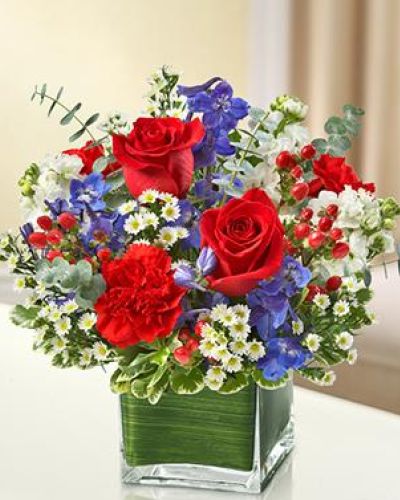 This lovely red, white and blue arrangement offers a beautiful reflection of your patriotism.

Fresh red roses, delphinium, stock, carnations and hypericum, designed in a cube vase make any occasion special.