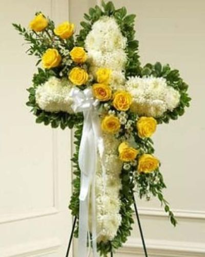 Send a beautiful floral tribute that expresses the love and sympathy you feel during this difficult time. This standing spray arrangement in the shape of a cross is created from fresh yellow and white flowers such as roses, football mums and more. Traditionally sent directly to the funeral home by family members or friends and displayed on a stand.