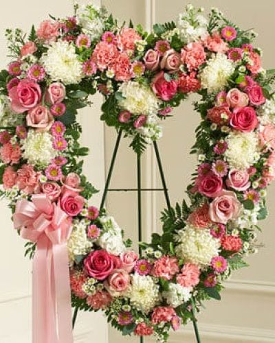 Commemorate them and the special place they will always hold in your heart with this heart-shaped floral arrangement. Crafted by our expert florists using fresh pink and white flowers including roses, stock, carnations and more, it's a beautiful way to send your deepest condolences to family, friends or any special person in your life. Traditionally sent directly to the funeral home by family members or friends and displayed on a stand.