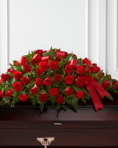 The FTD® Dearly Departed™ Casket Spray bursts with the love and passion that the deceased had for their life and loved ones. Rich red roses and carnations are gorgeously arranged amongst lush greens and accented with a red satin ribbon to create the ideal adornment for their casket at their final farewell service.