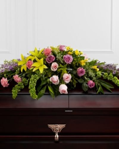 The FTD® Forever Beloved™ Casket Spray beautifully illuminates the atmosphere of their final farewell service. Lavender roses, pink roses, lavender larkspur, pink carnations, Bells of Ireland, yellow Asiatic lilies, yellow freesia, solidago and lush greens are arranged to create an extravagant display of floral beauty that offers comfort and peace to the friends and family of the deceased.