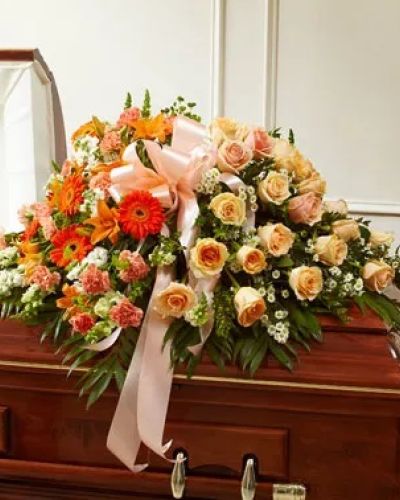 Send the perfect expression of your love and a tribute to a beautiful life. This arrangement features gorgeous long stem peach roses, orange Asiatic lilies, white snapdragons and more. Traditionally sent by the immediate family to the funeral home.
