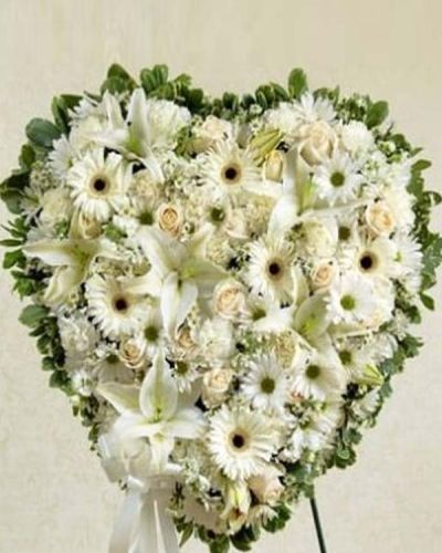 This solid heart standing spray makes a beautiful statement about your heartfelt compassion and sympathy. White flowers such as roses, lilies, Gerbera daisies, carnations and more form the solid heart which is tied to a wire easel with satin ribbon. Traditionally sent directly to the funeral home by family, friends or business associates.