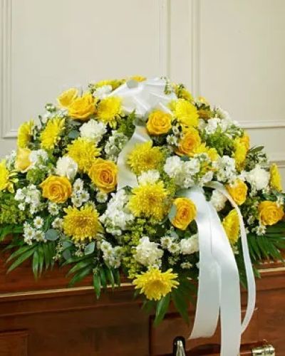 This beautiful half casket cover reflects your deepest sympathies and love for a life well lived. This display features gorgeous long stem yellow roses, white cremones, carnations and more accented by crisp greenery. Traditionally sent by the immediate family directly to the funeral home.