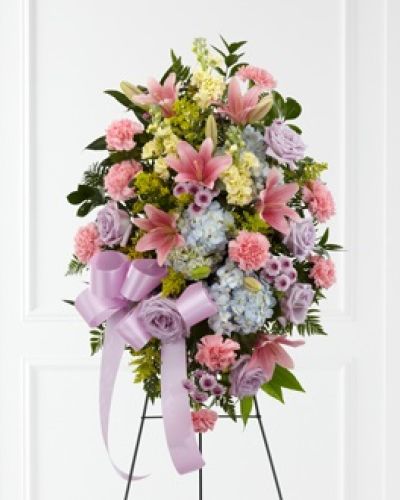 The FTD® Blessings of the Earth™ Easel is a soft and serene arrangement that elegantly honors the life of the deceased. Lavender roses, pink carnations, pink Asiatic lilies, blue hydrangea, yellow stock, lavender button poms, solidago and lush greens are beautifully accented with a lavender satin ribbon and displayed on a wire easel to create a gorgeous display for their memorial service.