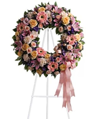 <div id="mark-1" class="m-pdp-tabs-marketing-description">Family and friends will recollect how special their loved one was with this gentle ring of pastel blooms. Highlighted with a pink satin ribbon, it is a lovely reminder of sweet memories and beautiful times shared.</div>
<div id="desc-1">
<ul>
 	<li>Peach roses, gerberas and carnations, pink asiatic lilies and lisianthus, along with purple limonium and lavender larkspur – accented by greens woven throughout – are presented on an easel-mounted wreath, ideal for a memorial occasion.</li>
</ul>
</div>