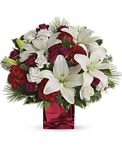 Filled with holiday charm. Red spray roses and white asiatic lilies are arranged to perfection in our red mirrored cube.