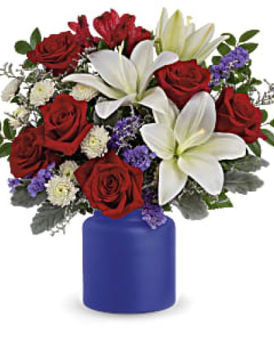 Revel in the crisp, classic color scheme of pristine white lilies and radiant red roses, presented in a cobalt-hued, frosted glass jar.