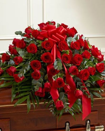 Red roses are a powerful symbol of undying love. This half casket cover, crafted with exquisite care by our expert florists, features long stem red roses and vibrant greenery for a beautiful and fitting final tribute. Traditionally sent by the immediate family to the funeral home.
